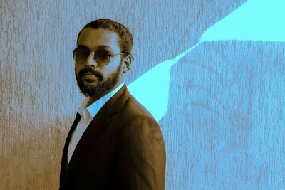 Portrait of young bearded man standing against wall