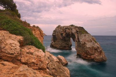 Rocks on sea shore against sky