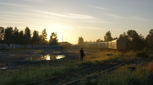 Man on landscape against sky during sunset
