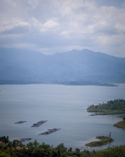 Scenic view of lake by mountains against sky