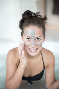 Young woman using face mask