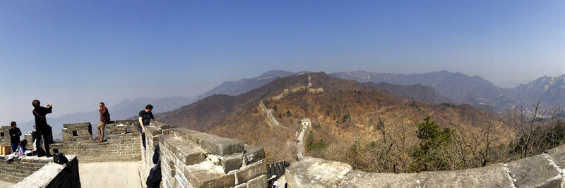 People standing on great wall of china against clear blue sky