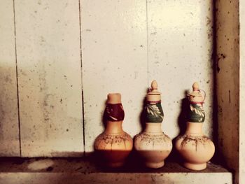 Close-up of bottles on table against wall