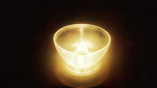 Low angle view of illuminated light bulb in darkroom