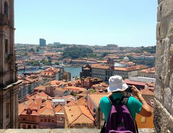 Man photographing townscape against sky