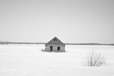 Built structure on snow covered land against clear sky