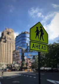 Road sign against sky in city