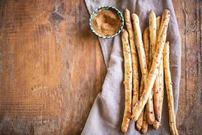 Grissini - italian bread sticks with dried herbs on a wooden background. copy space.