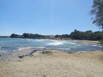 Scenic view of beach against blue sky