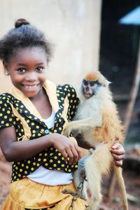 Portrait of cute girl holding monkey