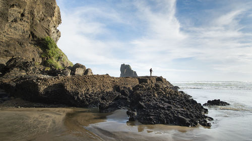 Full length of man standing on rock against sky