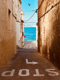 Sidewalk by sea against sky