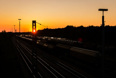 Railroad tracks against sky during sunset