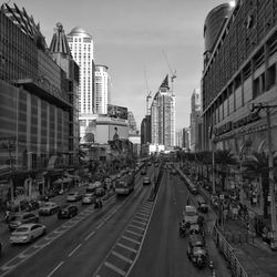 Vehicles on road in city against sky