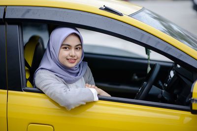 Portrait of a smiling young woman in car