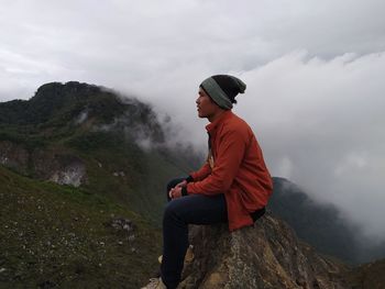 Man standing on rock against mountain range