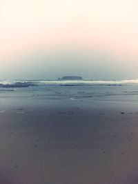 Scenic view of beach against clear sky during sunset