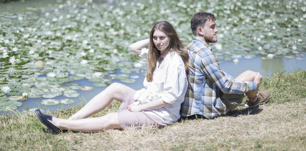 Young couple sitting lakeshore