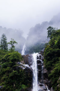 Scenic view of waterfall during foggy weather
