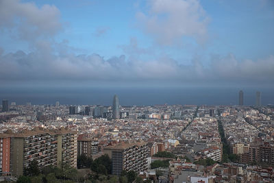 Aerial view of buildings in city against sky