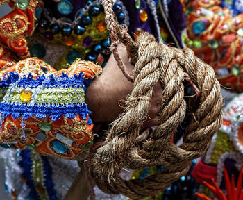 Midsection of man holding ropes