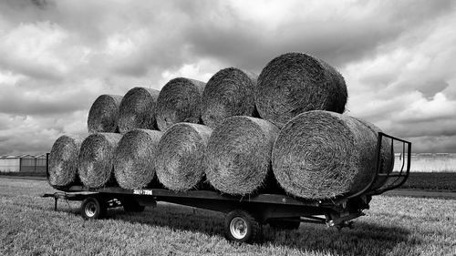 Hay bales on field against sky