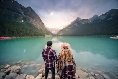 People standing at lake against sky