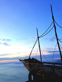 Sailboats moored on sea against blue sky