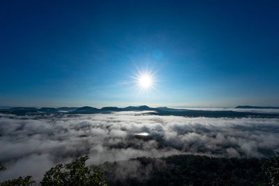 Scenic view of clouds over landscape against bright sun