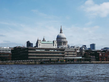 River by buildings against sky in city