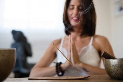 Portrait of a young woman sitting on table