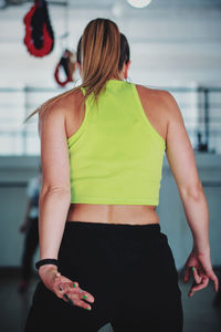 Rear view of woman standing against wall