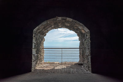 Arch window in old building against sky