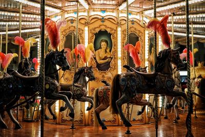 View of carousel horses in amusement park