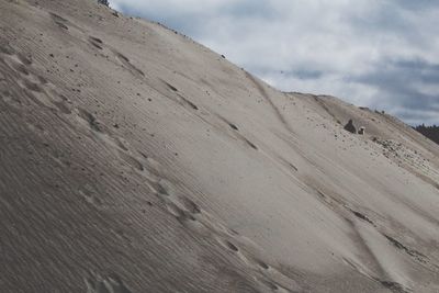 Scenic view of sand dunes against sky