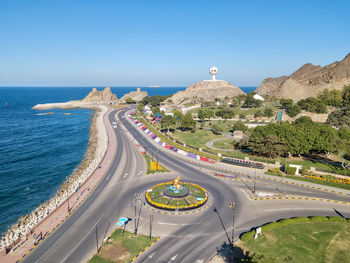 Aerial view of city by sea against clear sky