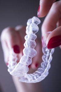 Cropped hand of woman holding artificial teeth