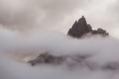 Low angle view of rocks in mountains against sky