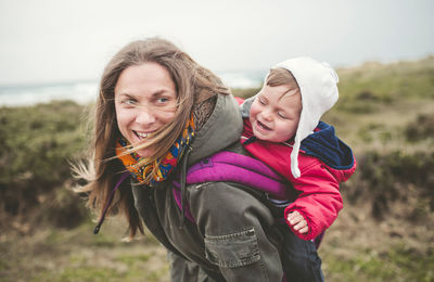 Smiling mother carrying baby boy