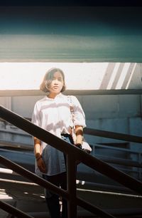 Portrait of a smiling young woman standing on steps