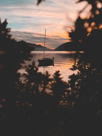 Silhouette sailboats on sea against sky during sunset