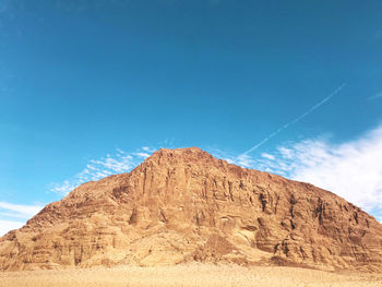 Scenic view of arid landscape against blue sky