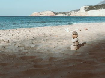 Toy sitting on shore at beach against sky