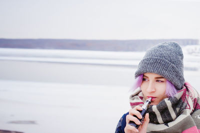 Close-up of young woman using mobile phone in sea