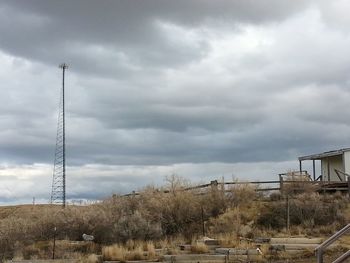 Built structure on landscape against cloudy sky