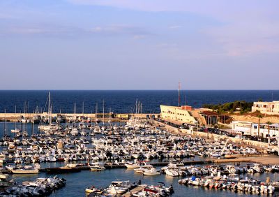 High angle view of sailboats moored in sea against sky