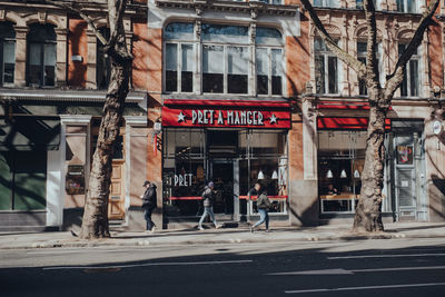 People walking on street against buildings in city