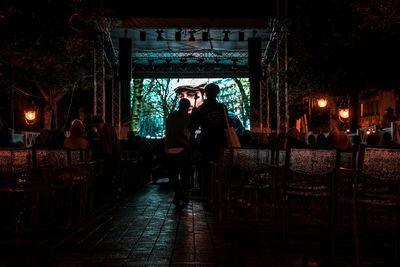 People standing in illuminated restaurant at night