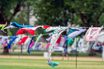 Multi colored flags hanging on rope in field