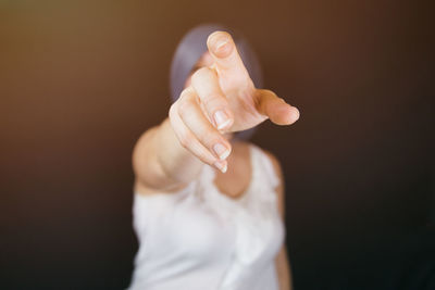 Portrait of woman gesturing against black background